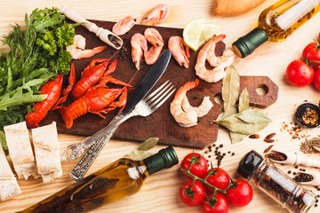 Silverware on the board with spices, cherry tomatoes and cancers