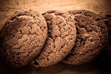 Three dry cookies lie on a wooden board