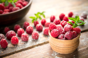 Ripe sweet raspberries on wooden background