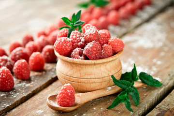 Ripe sweet raspberries on wooden background