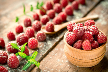 Ripe sweet raspberries on wooden background