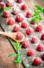 Ripe sweet raspberries on wooden background