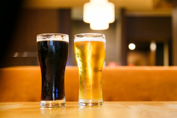 Two glasses of fresh cold beer. One dark, the other light.