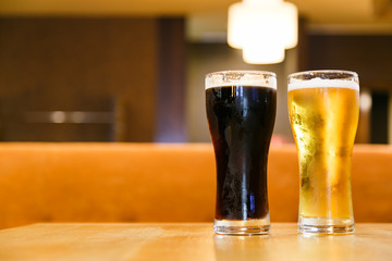 Two glasses of fresh cold beer. A glass  dark , the other light.