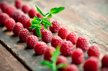 Ripe sweet raspberries on wooden background