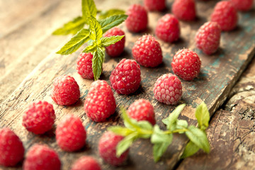 Ripe sweet raspberries on wooden background