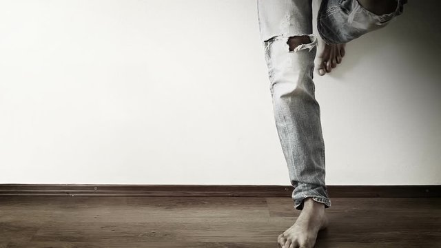 Stylish rock musician thump out the rhythm near the white wall