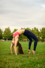 Fototapeta premium Pretty woman doing yoga exercises in the park