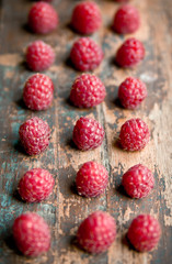 Ripe sweet raspberries on wooden background