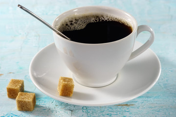 Cup of coffee in early morning sun rays