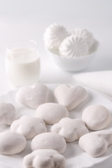 High key. The gingerbread on a platter. A lot. A glass of milk. Marshmallows. On a white background. Vertical.