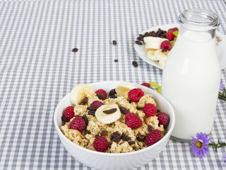 granola with fruits and bottle of fresh milk
