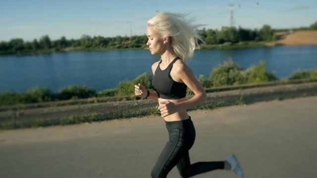 Athletic Woman Running near the Beach. Female Runner Jogging. Outdoor Workout.