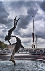 Obraz na płótnie Canvas St Katharine Docks 'Girl with a dolphin' fountain/Girl And Dolphin Statue And Fountain near Tower Bridge in London