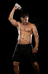Fototapeta na wymiar strong sport man pouring water on his hair sweating after training hard on gym bodybuilding workout