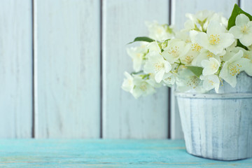 Fresh jasmine flowers in a bucket on wooden table