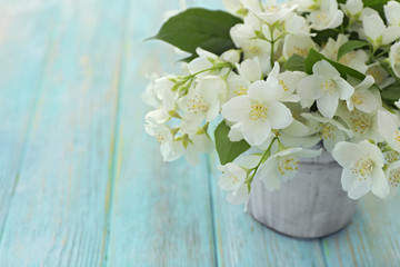 Fresh jasmine flowers in a bucket on wooden table