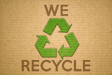 Recycle green symbol on cardboard with text we recycle
