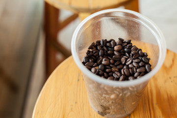 cup of  coffee beans on wooden chair