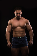 Fototapeta na wymiar handsome muscular bodybuilder posing on a black background