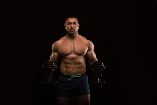 handsome muscular bodybuilder posing on a black background
