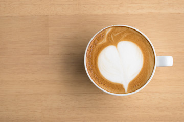 Top view latte art coffee on wooden table.Close up with copy space.