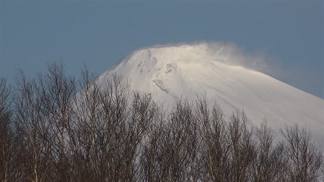 The mountain and the volcano Avacha snowy peaks spewing warm vapors from the earth