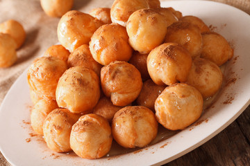 loukoumades donuts with honey and cinnamon close-up. Horizontal
