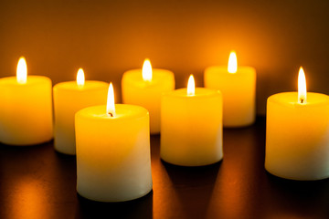 closeup to burning candles in darkness