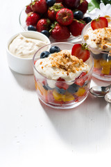 Assorted fresh fruit with custard on white table, vertical