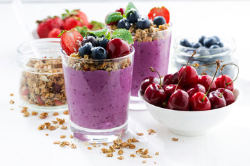 Blueberry dessert with granola in glass on a white background