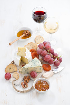 molded cheeses, fruit and snacks on a white wooden table