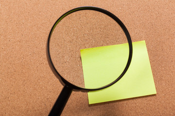Black magnifying glass, yellow sticky blank notes