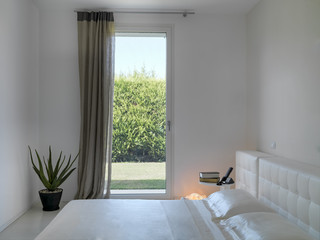 detail of interior view of a modern bedroom overlooking on the garden
