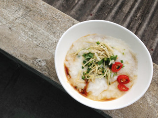 asian food - a bowl of congee with minced pork on grunge backgroundkeyword