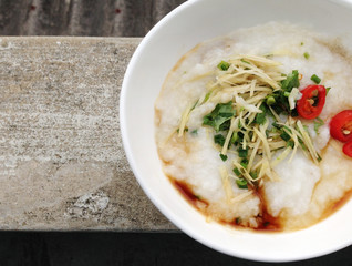 asian food - a bowl of congee with minced pork on grunge background