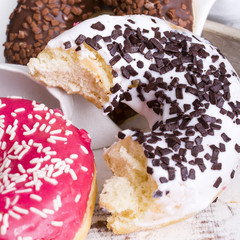 bitten donuts with icing on a white napkin