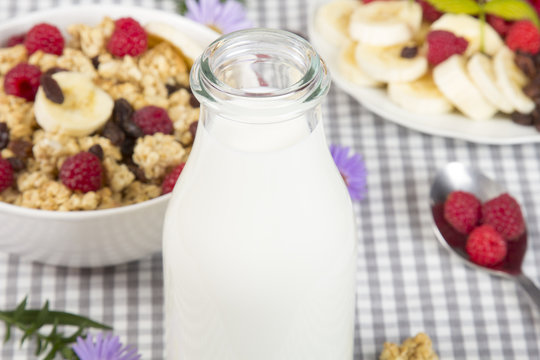 bottle of fresh milk and granola with fruits