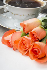 cup of coffee and a bouquet of roses on a tray