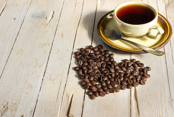 Чашка черного кофе и кофейные зерна на деревянном...