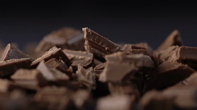Falling pieces of chopped chocolate with cocoa