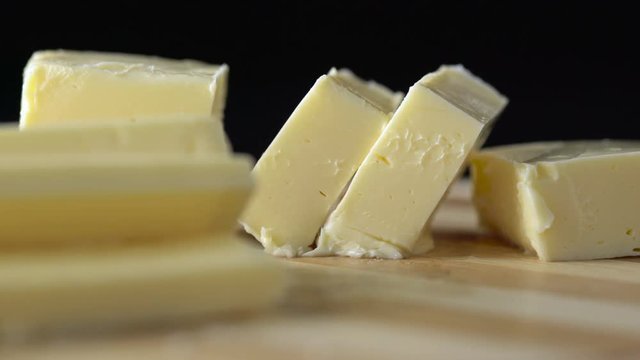 Sliced pieces of butter on wooden background