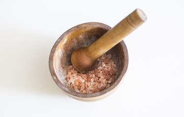 Himalayan pink salt in a wooden bowl isolated on white background