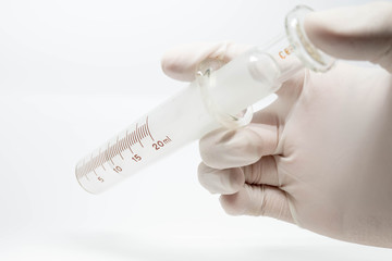 Old syringe medical equipment on hand with examination glove