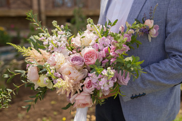 beautiful wedding bouquet in the hands of the groom