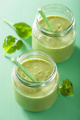 healthy green smoothie with spinach mango banana in glass jars