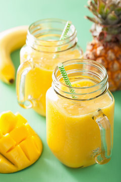 healthy yellow smoothie with mango pineapple banana in mason jar