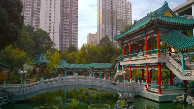 Video 3840x2160 - Graceful cement bridge of the famous Wong Tai Sin temple in downtown Hong Kong, with a beautiful pond and garden.