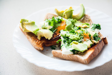 two eggs on toasts with avocado