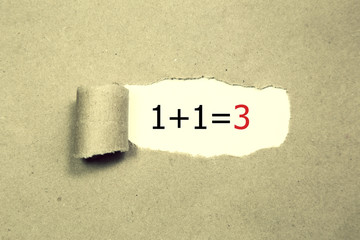 1+1=3 written under torn Brown paper.Business, technology, internet concept